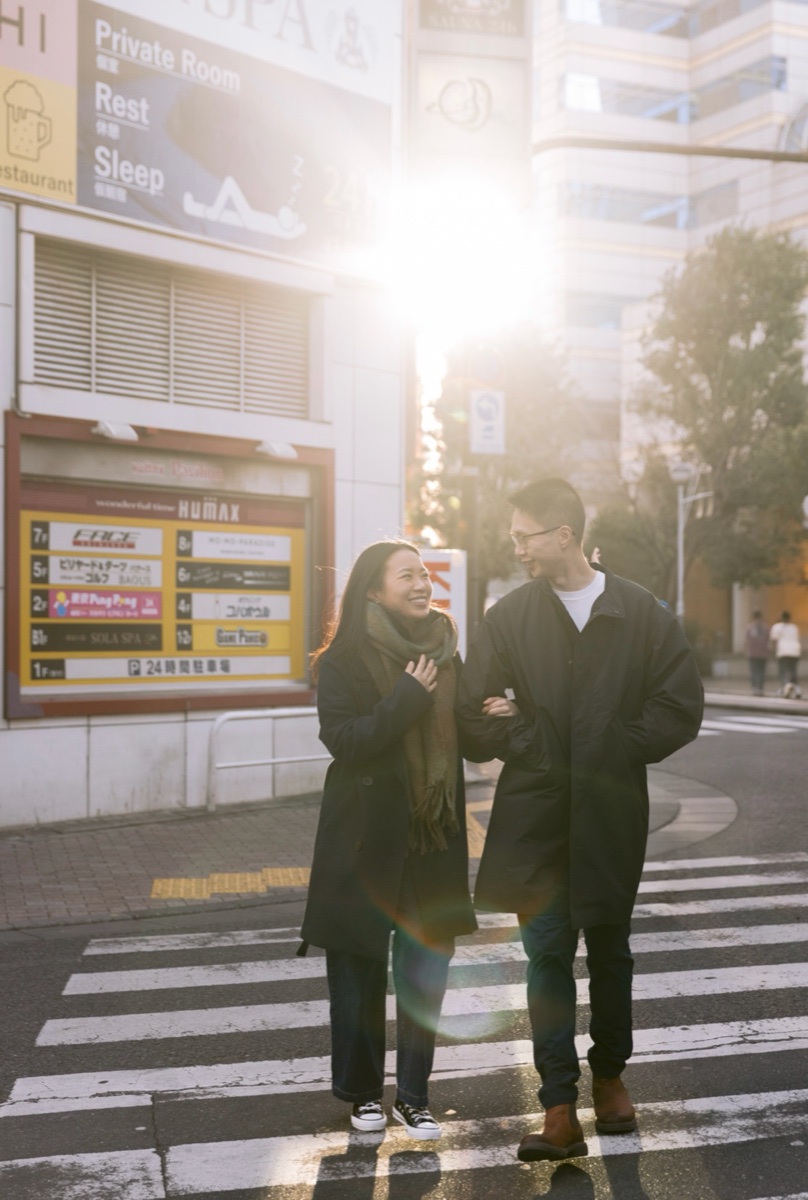 Couple crossing a street near Shinjuku Station in low sun