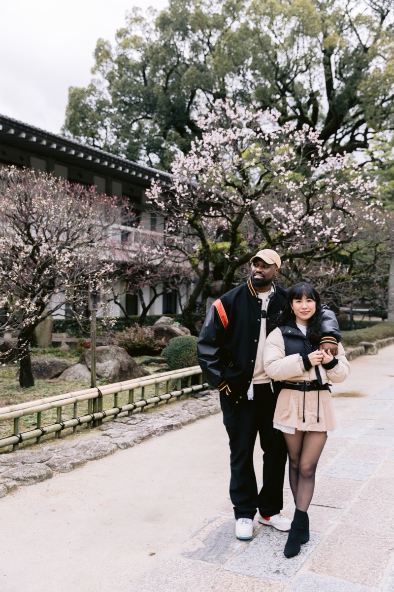 Couple standing under plum blossoms at a shrine
