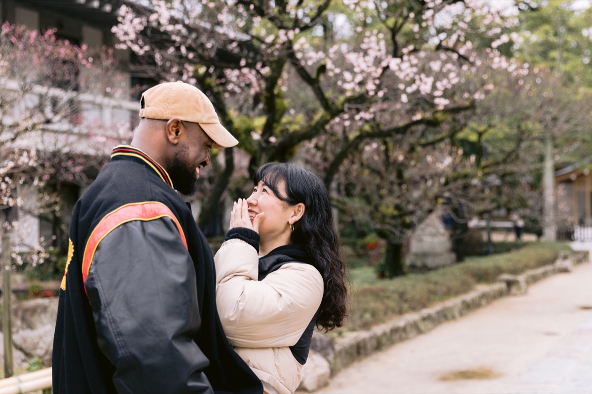 Couple laughing under plum blossoms at a Tokyo shrine